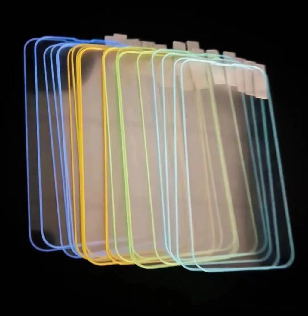 Fluorescent pink tempered glass screen protector glowing on an iPhone 13 in a dark room.