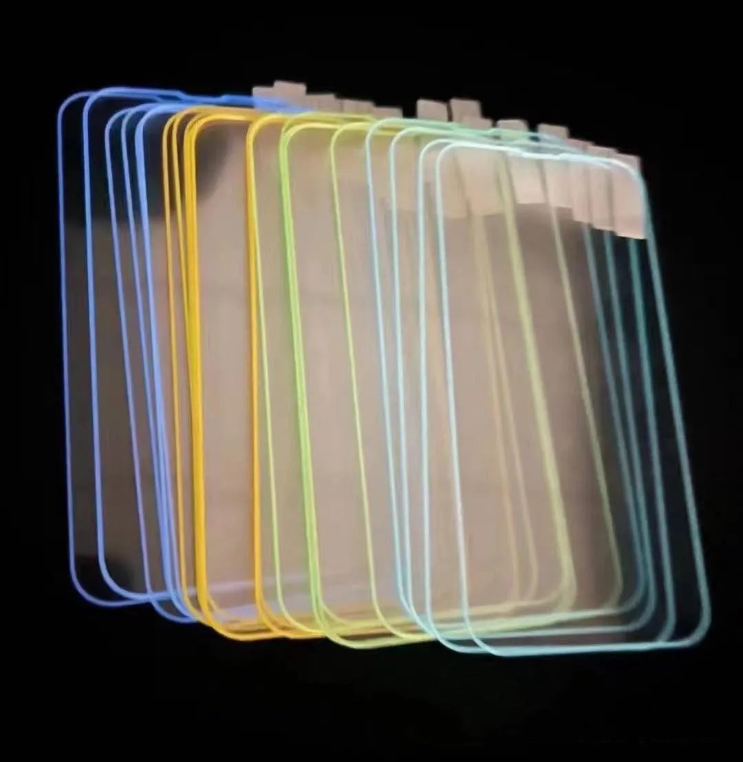 Fluorescent pink tempered glass screen protector glowing on an iPhone 13 in a dark room.