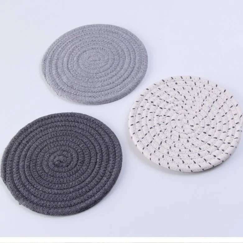 Three round cotton cord coasters in blue, measuring 18cm diameter, on wooden table