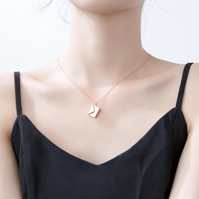 Titanium steel envelope pendant necklace with chain on a woman's neck, gold finish