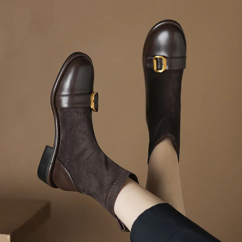 Black women's ankle boots with lace-up front and belt buckle stitching detail.
