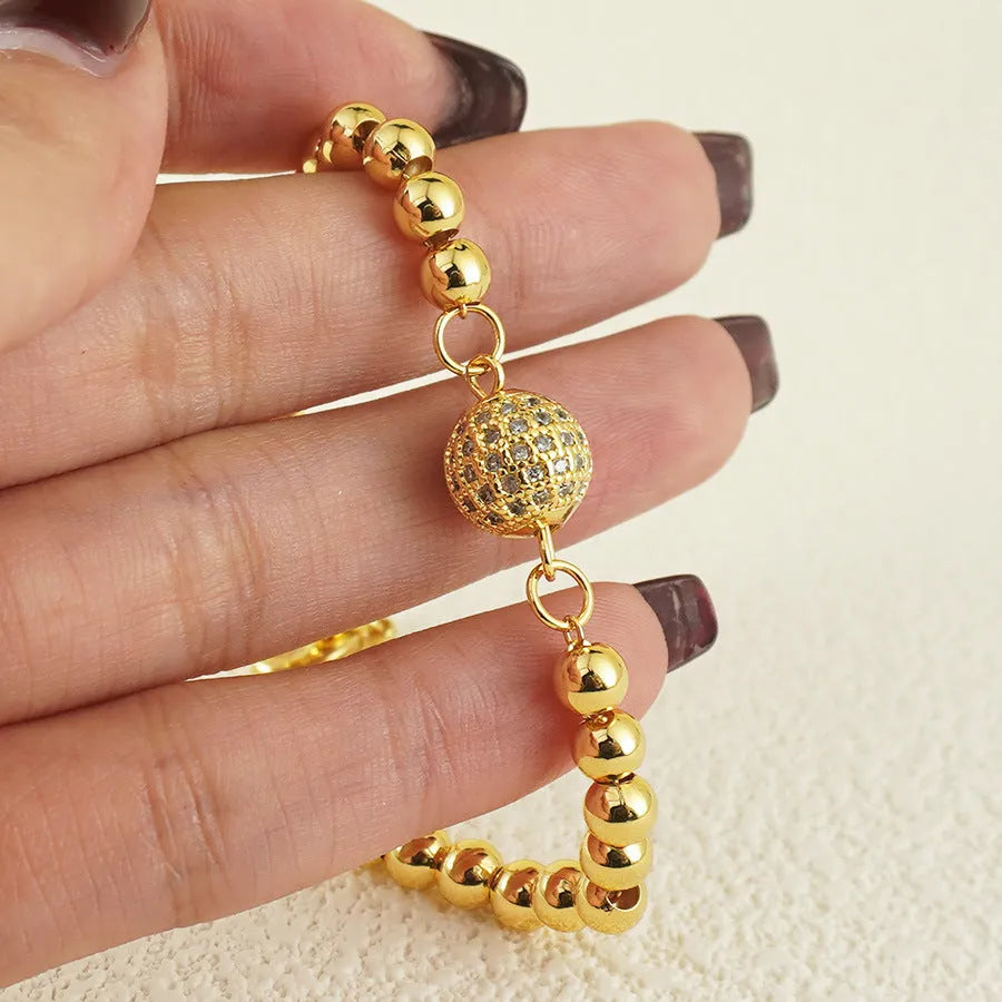 Close-up of a women's copper bracelet with a heart shape design and round zircon stone accents in an Arabic style.