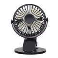Small white USB clip fan with plastic blades attached to a desk edge, showing piano button switch and brushless motor.