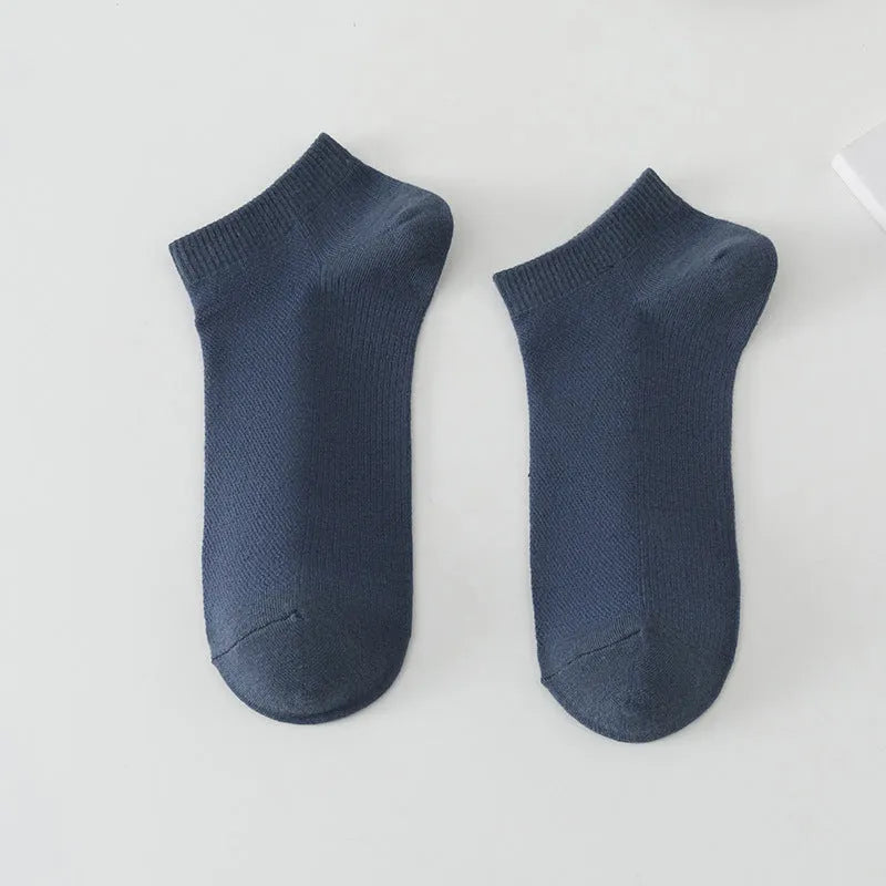 A pair of solid colour low-cut men's boat socks made from breathable polyester fabric.