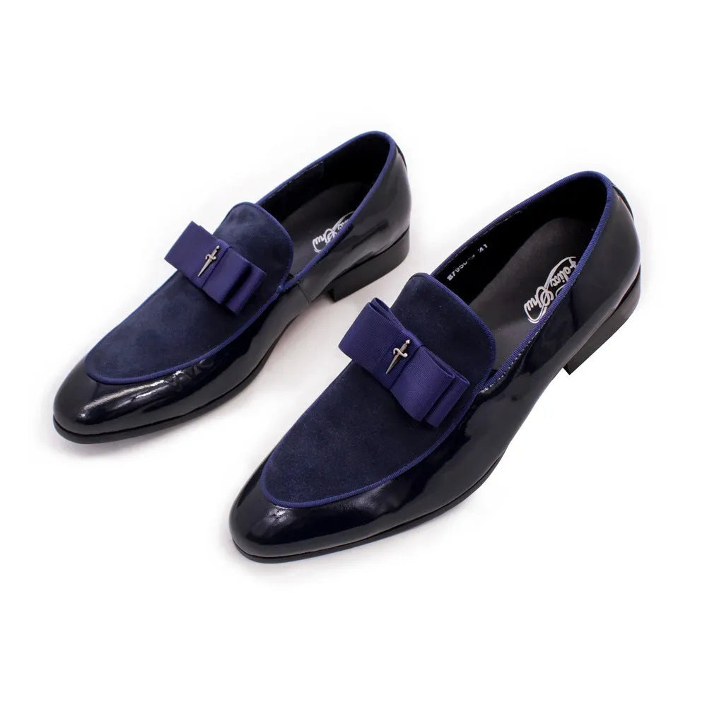 Men's black and brown tassel loafers with a matte and patent leather upper on a wooden floor.