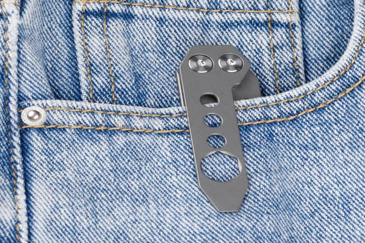 Titanium alloy multi-tool with crowbar edge, screwdriver tip, and bottle opener notches on a stone wash finish background.