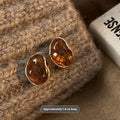 Set of three pairs of geometric holiday earrings: round studs, irregular amber studs, and tassel drop earrings.