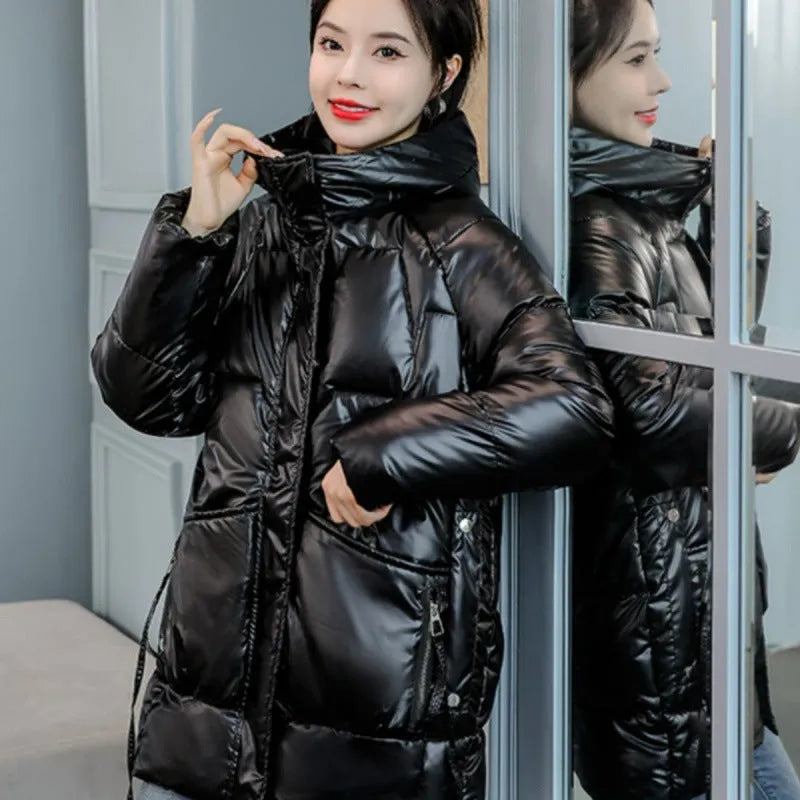 Women's loose fit hooded winter jacket in black, shown on a model, featuring a front zip and acrylic lining.