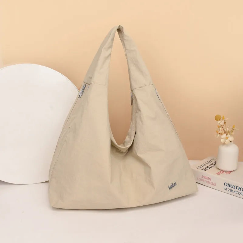 Soft heart-shaped nylon underarm bag for women shown in black, blue, khaki, and yellow.