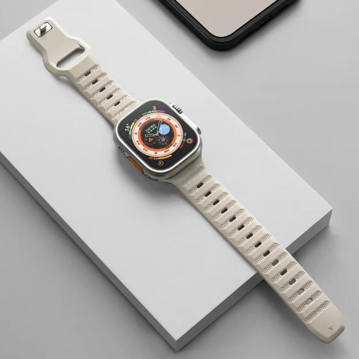 Black fluoro rubber Apple Watch band with silver T-buckle on a wrist, showing connection to Apple Watch case.