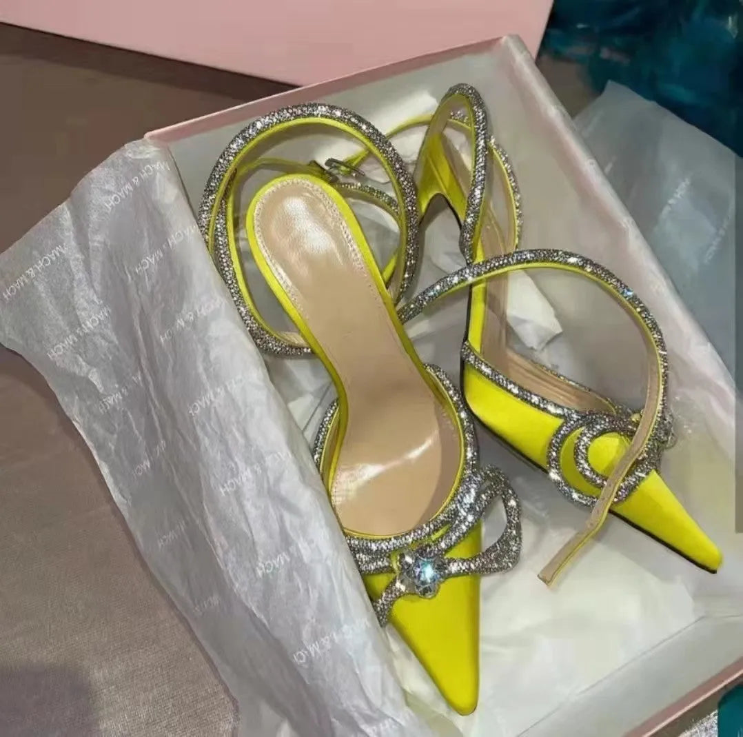 Women's black stiletto heel sandals with a silk back bandage and pointed toe on a white background.