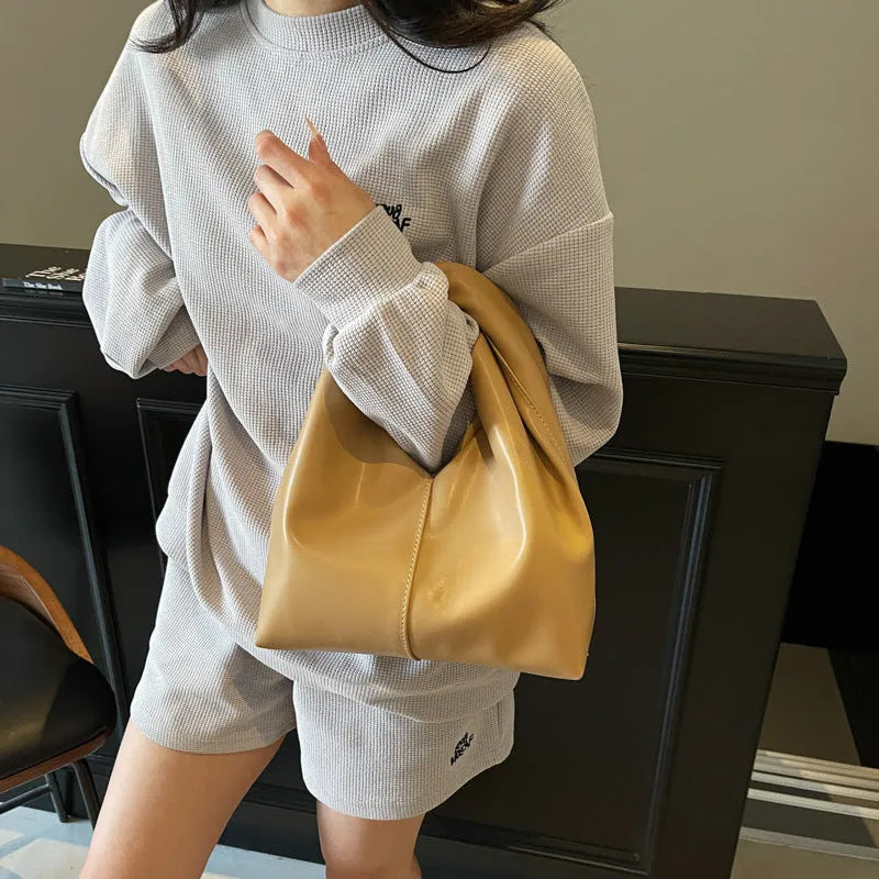 PU women's casual handbag in dumpling shape with sandwich pocket, shown in multiple colours.