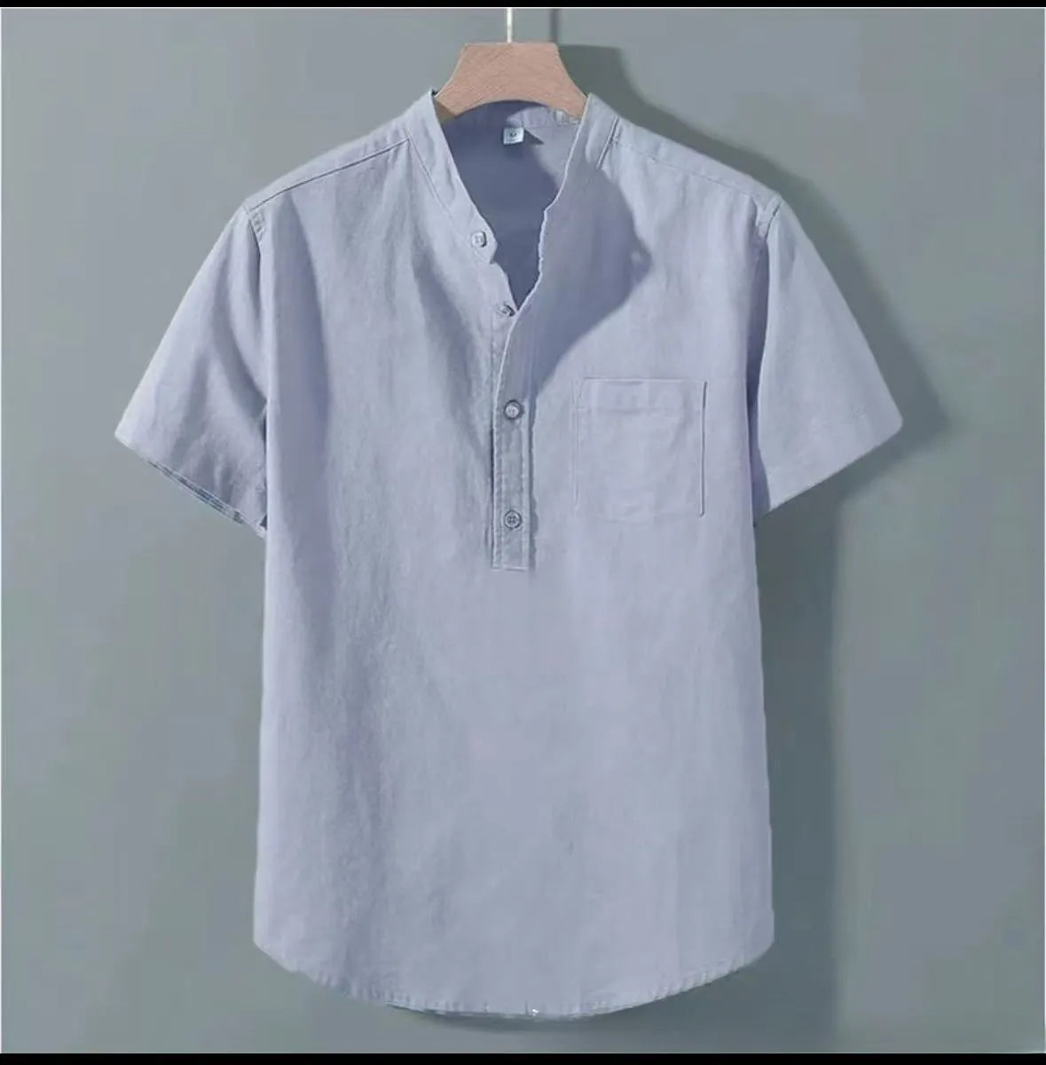 Man wearing a beige slub linen casual shirt with a stand collar and short sleeves.