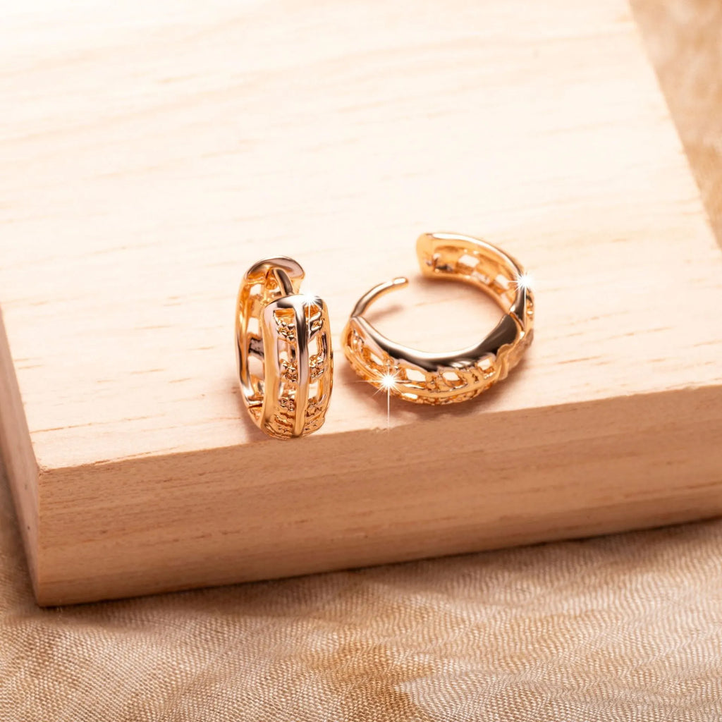A pair of rose gold copper earrings featuring a hollowed-out leaf design with a heart shape detail.