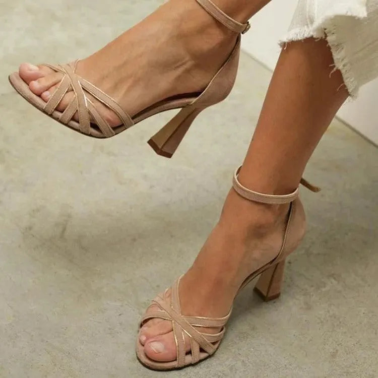 Apricot coloured suede women's peep toe high heel sandals with a bag heel on a white background.
