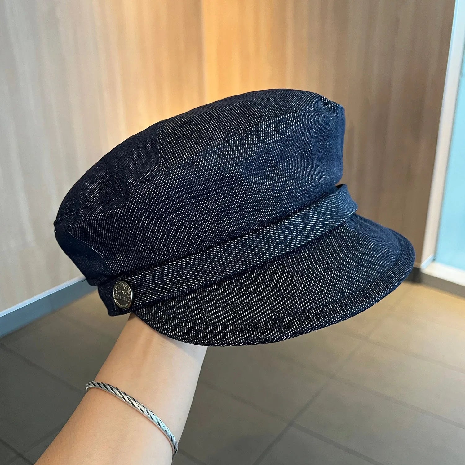 Dark blue denim newsboy hat with octagonal retro design and adjustable sizing