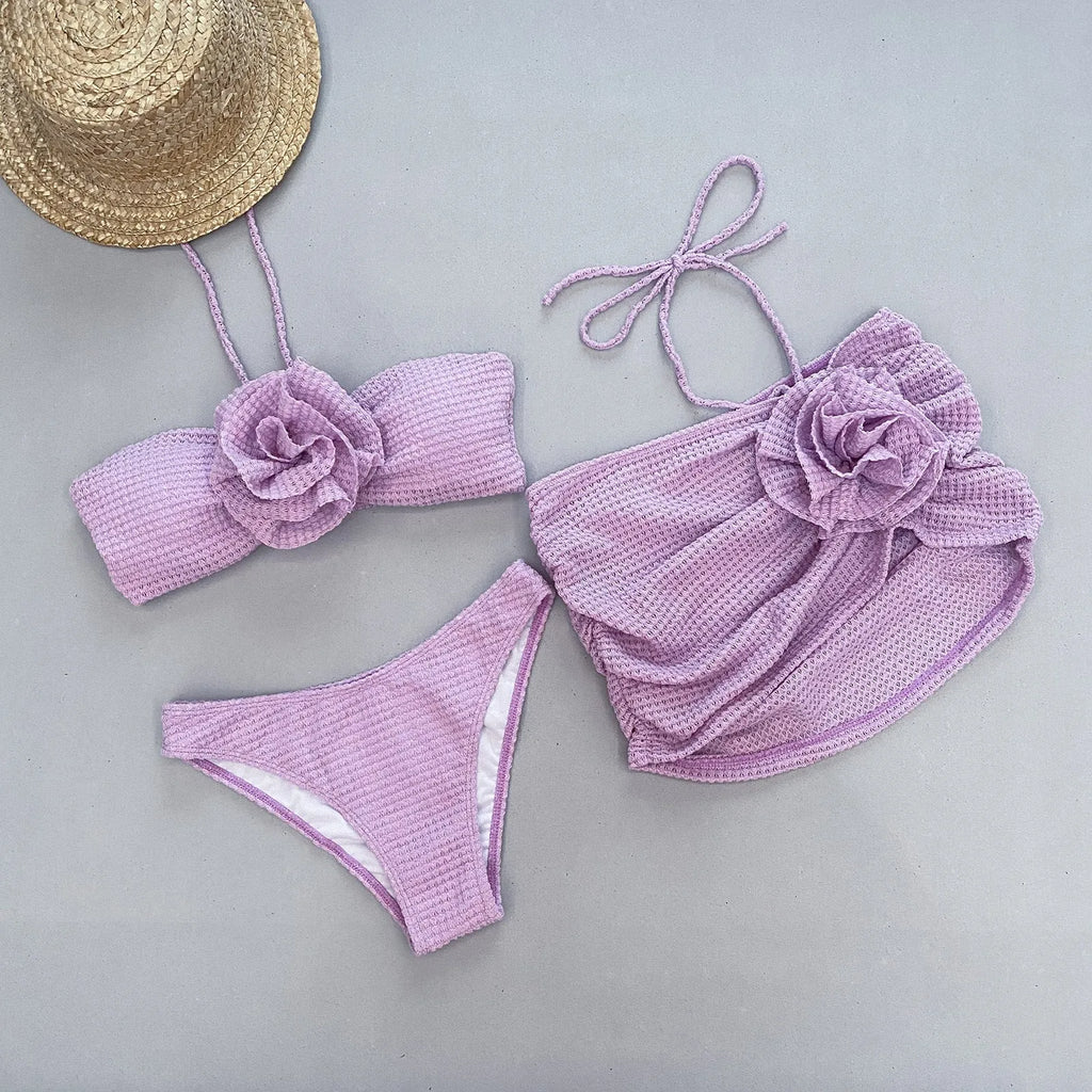 Women's purple 3D flower split bikini set with bra, panties, and skirt on a mannequin.
