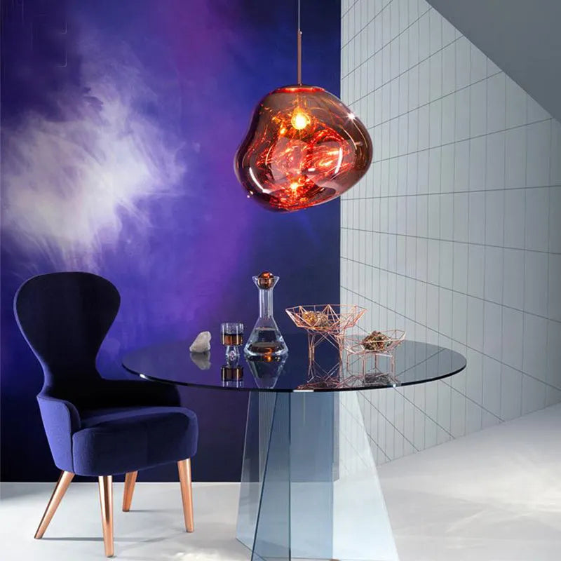 A modern irregular shaped glass chandelier with a Nordic design in a gold finish, hanging from a ceiling.