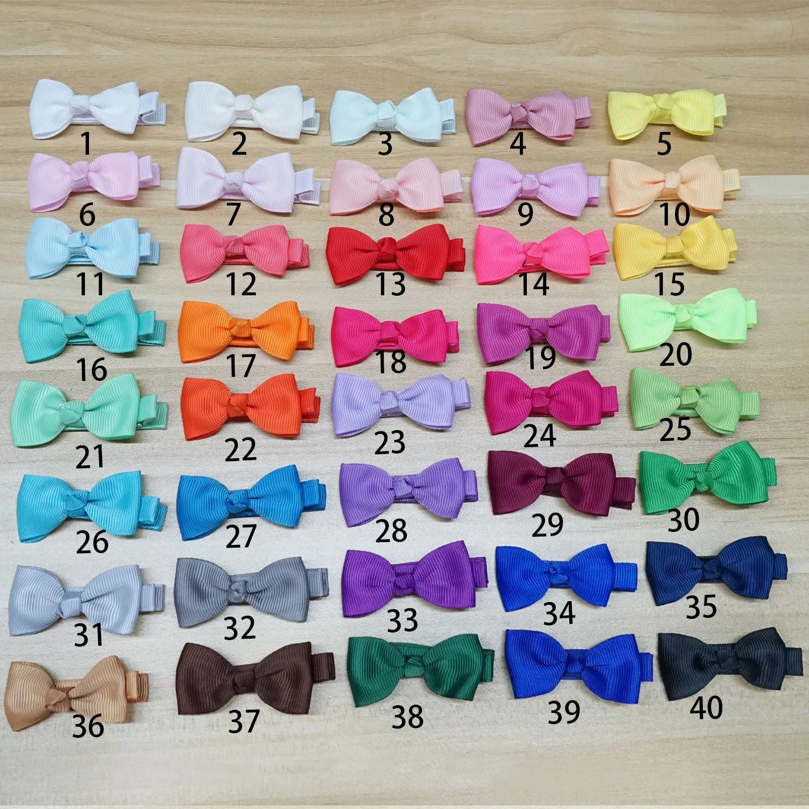 Assortment of pastel-coloured baby hair clips including barrettes and bows on a white background.