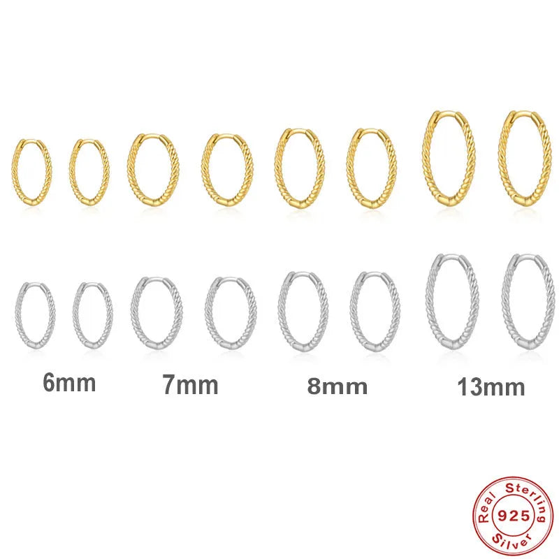Close-up of a twisted sterling silver round hoop earring in gold colour, showing geometric design.