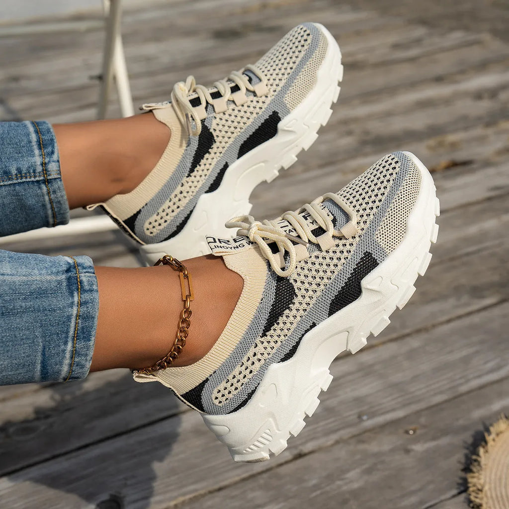 Women's Flyknit mesh lace-up sneakers in grey and white with a low rubber sole.
