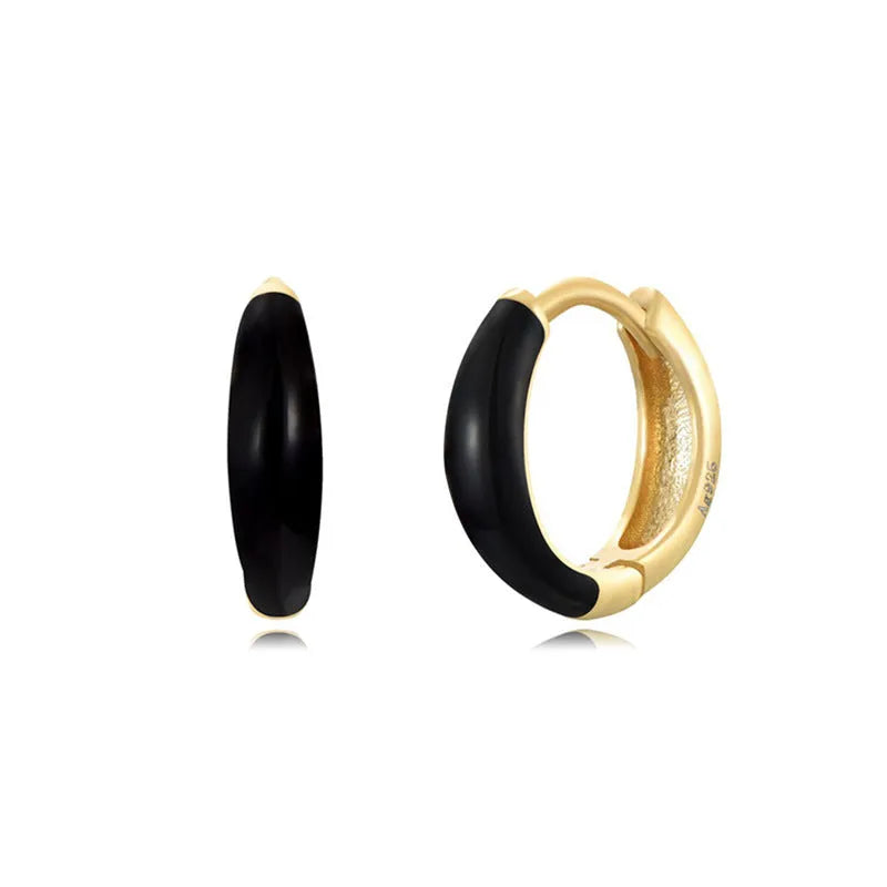 A pair of oval glossy light green epoxy dome earrings on a silver-toned U-shaped geometric wire, against a neutral background.