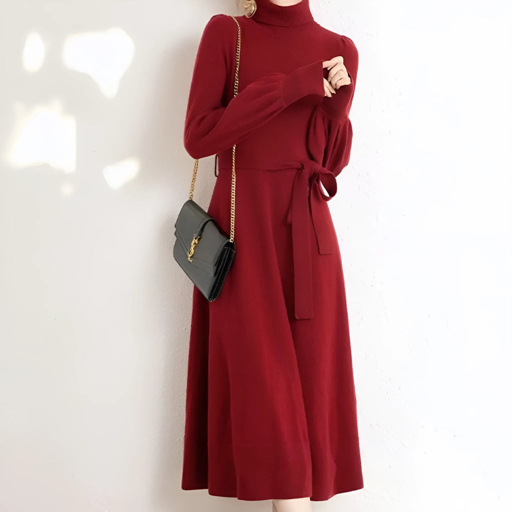 Woman wearing a rose red turtleneck knitted dress with long sleeves and a loose, flared big hem.