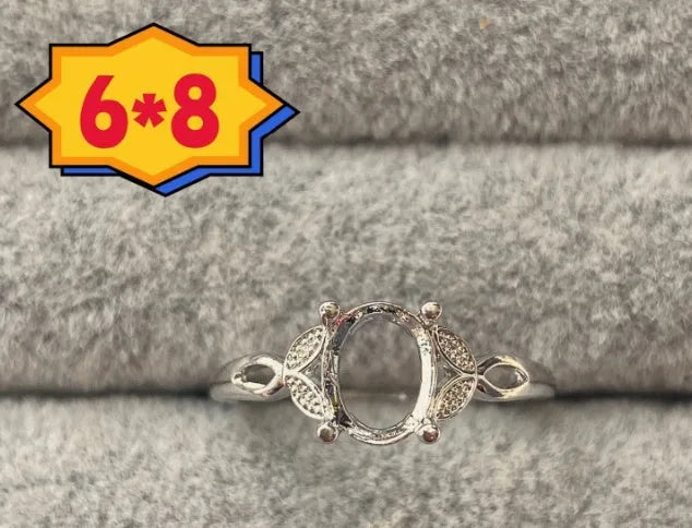 Oval denier fashion ring with open mouth setting, five-pointed star, and 6x8mm stone on copper band.