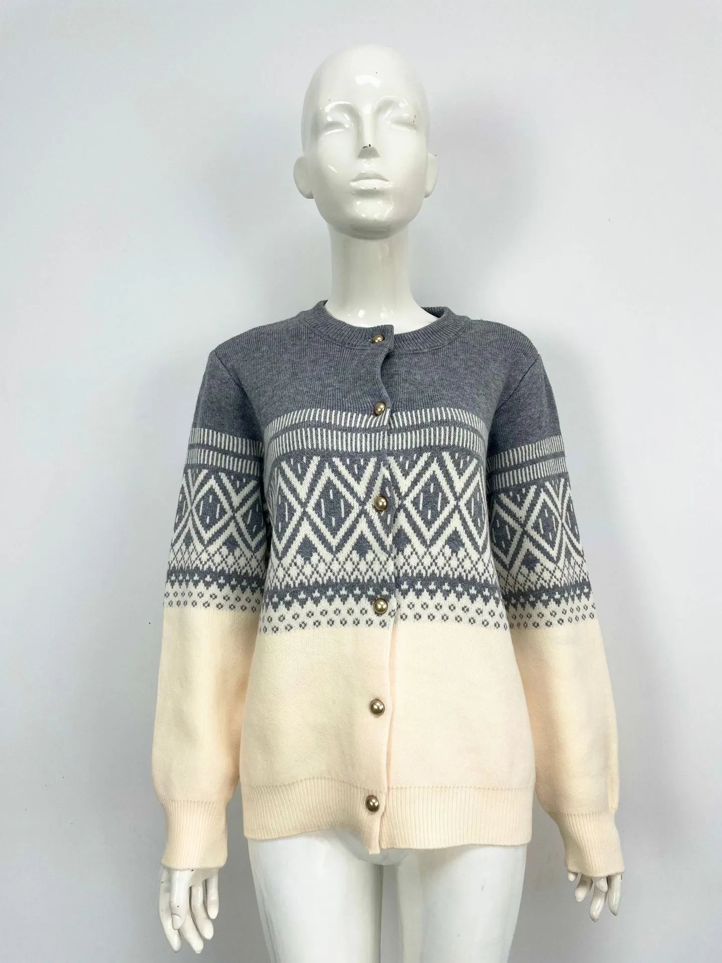 Woman wearing a grey alpaca wool cardigan with a long-sleeve diamond knit pattern in contrasting colours.