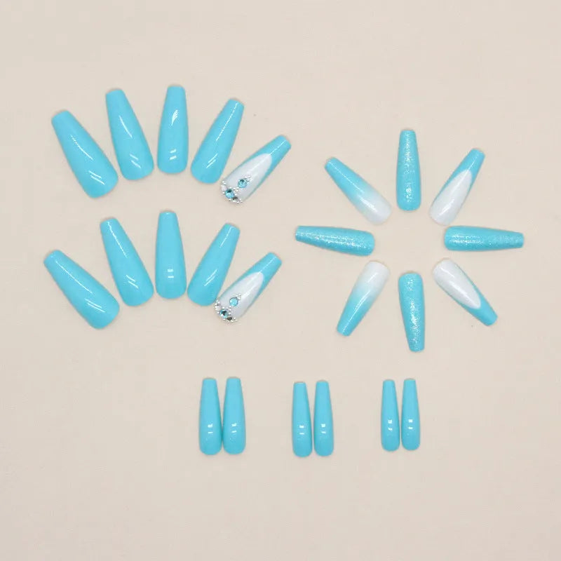 Long ballet shaped false nails in solid blue diamond colour with glitter adhesive glue.