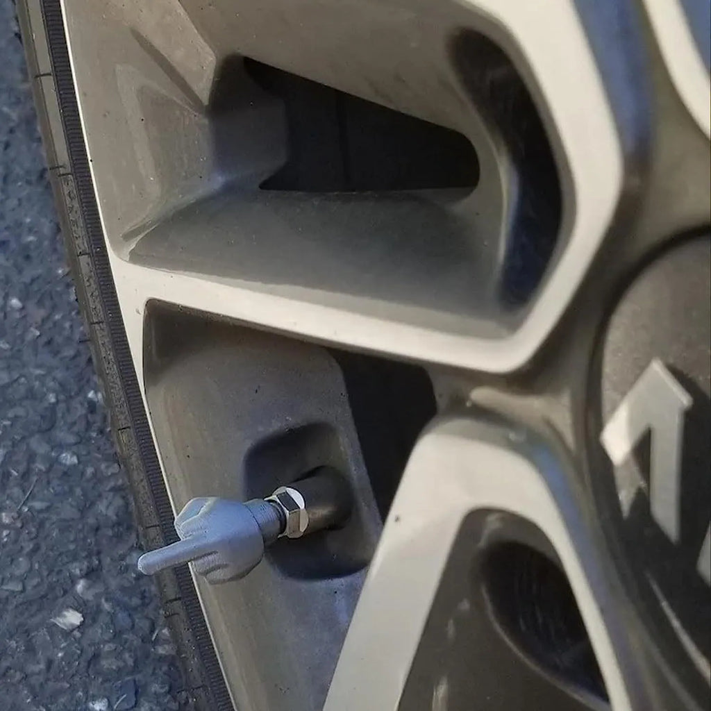 Four latex tyre valve caps showing two skin colour and two black pieces for car tyre protection