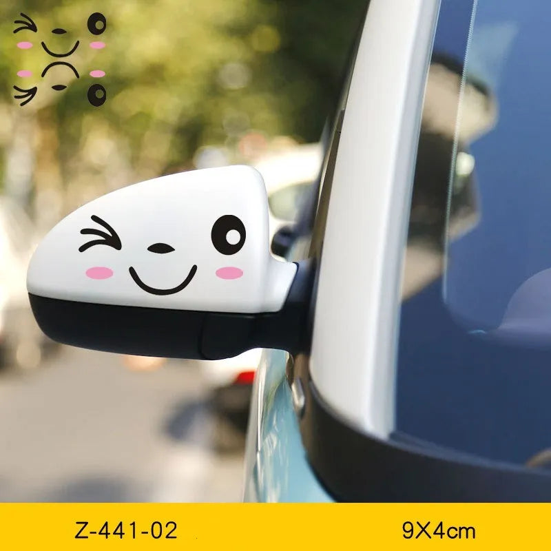 Pair of reflective cartoon car stickers with cute eyes on a car rearview mirror.
