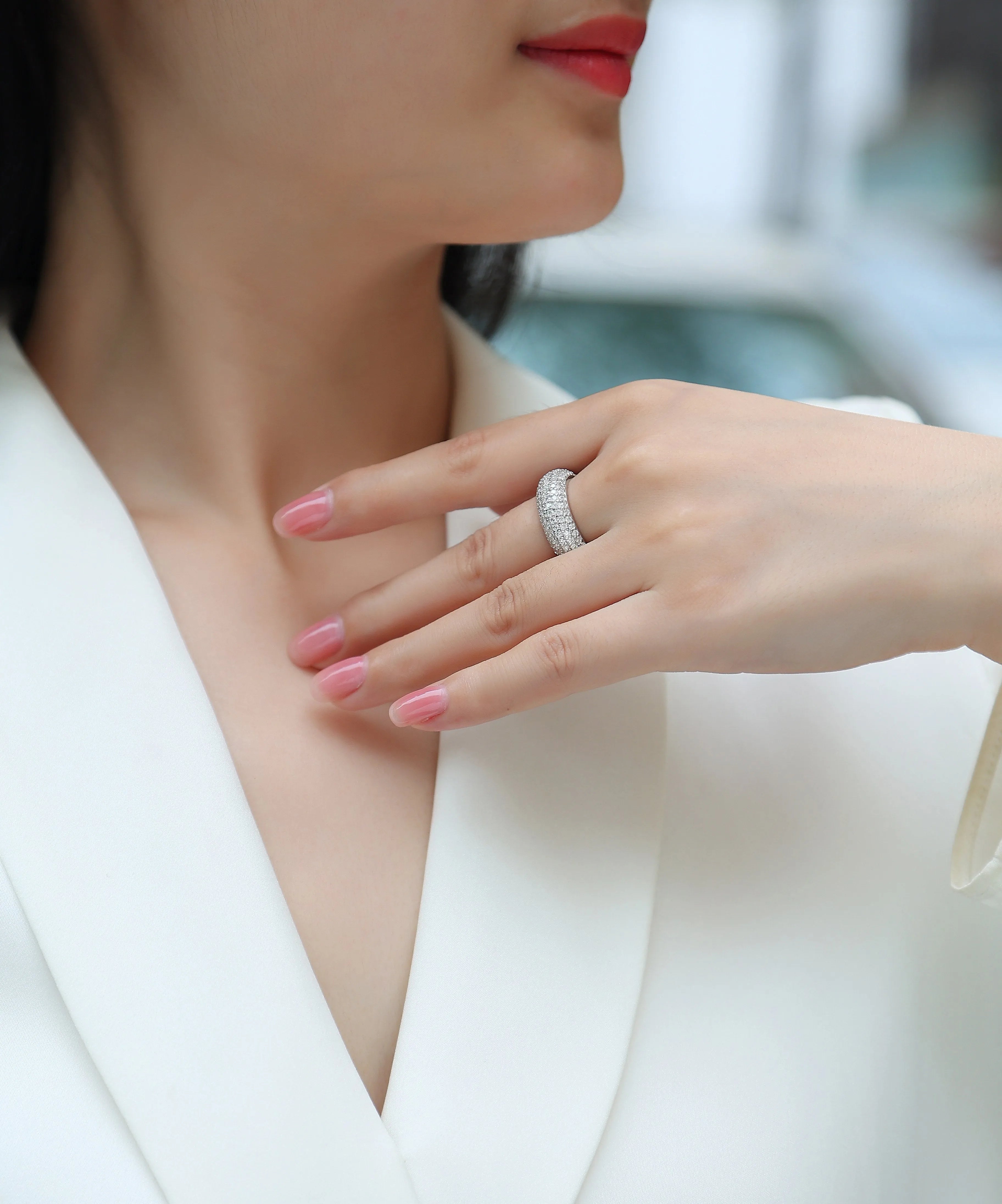 Moissanite wedding ring with S925 silver platinum plated band on flat surface showing stone and certificate