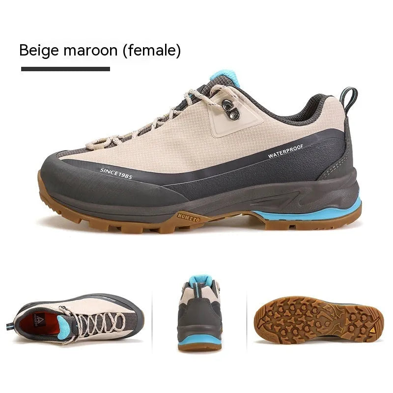 Men's low-top hiking boots in black with leather mesh upper and rubber outsole on a rocky path.