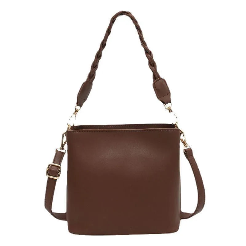 Retro style khaki crossbody bucket bag with weaving detail on the front.