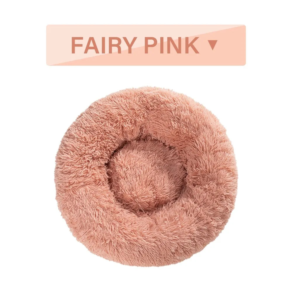 Fluffy grey donut-shaped dog bed with high plush sides on a wooden floor.