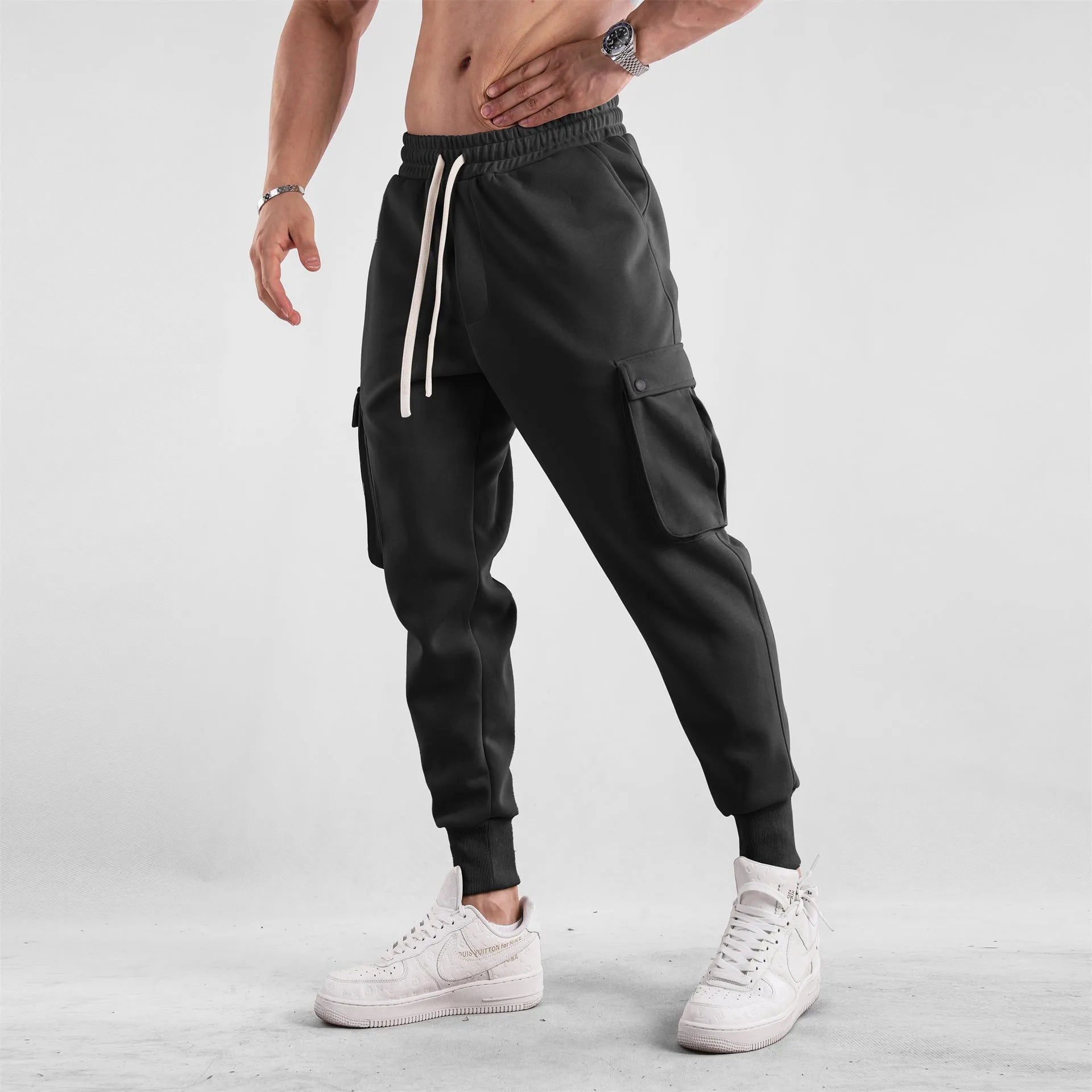 Men's loose-fit apricot coloured cotton sports trousers with an ankle tie and side pockets on a neutral background.