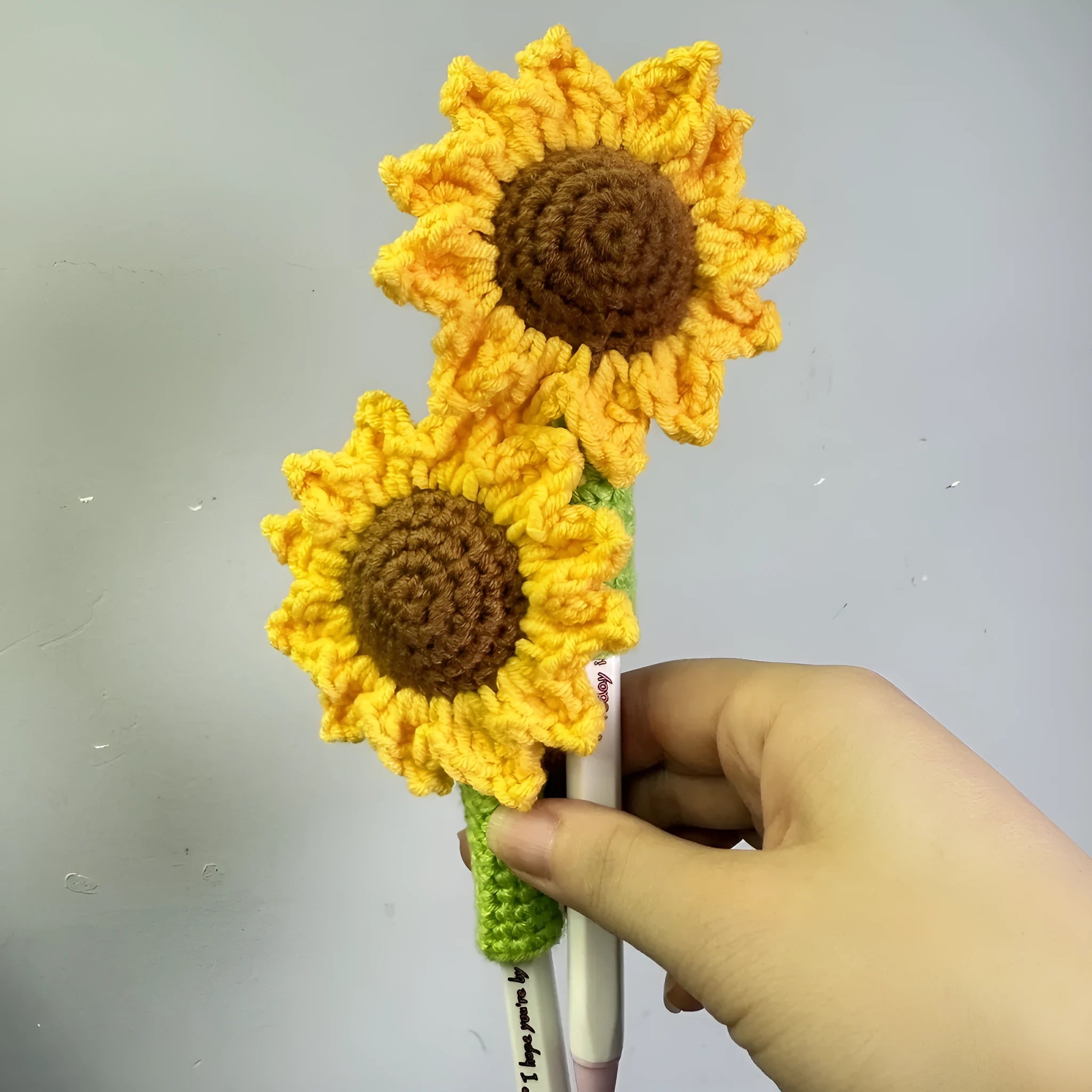 Hand-woven sunflower pen cover made from natural wheat straw.