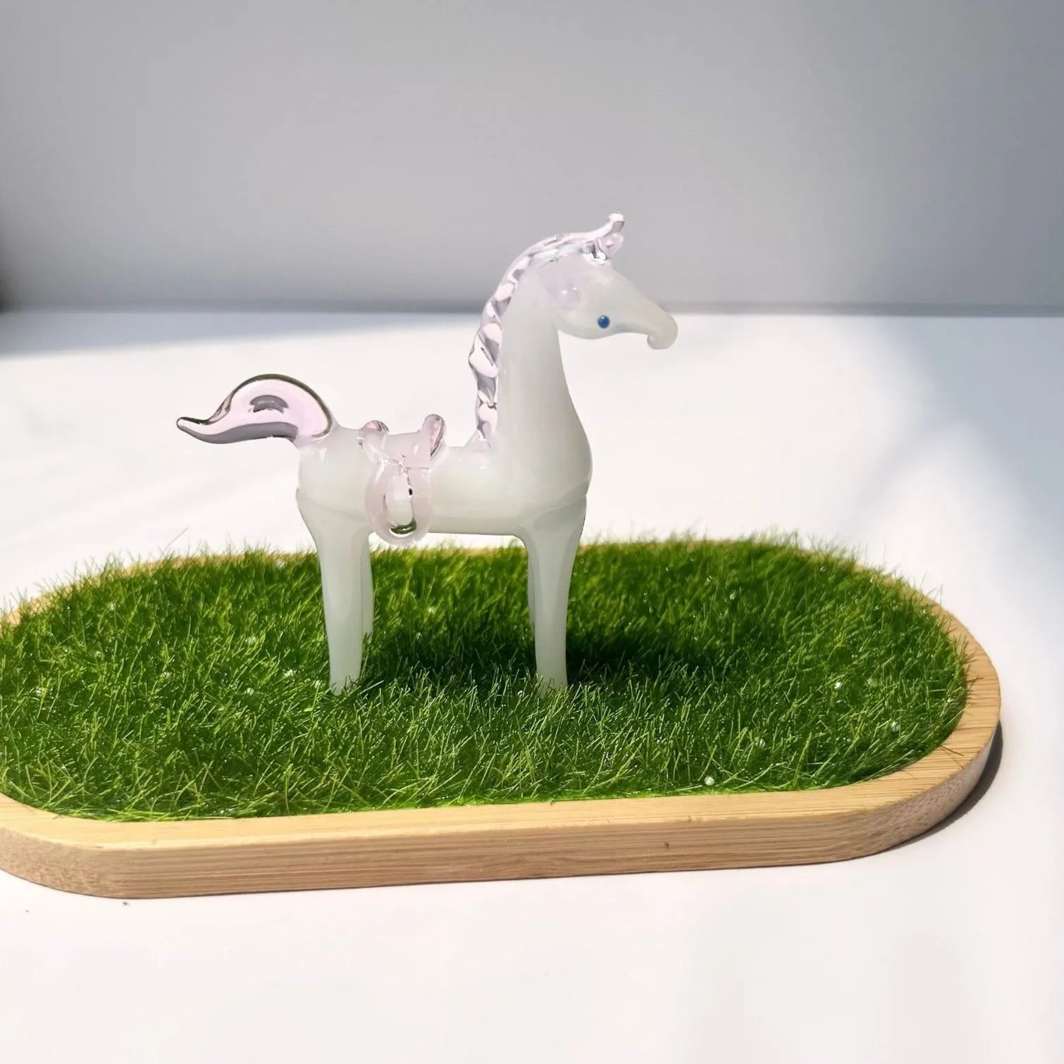 A smooth glazed horse figurine ornament in a modern minimalist style on a table.
