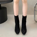 Brown square toe women's ankle boot with a side zip and a mid kitten heel on a plain background.