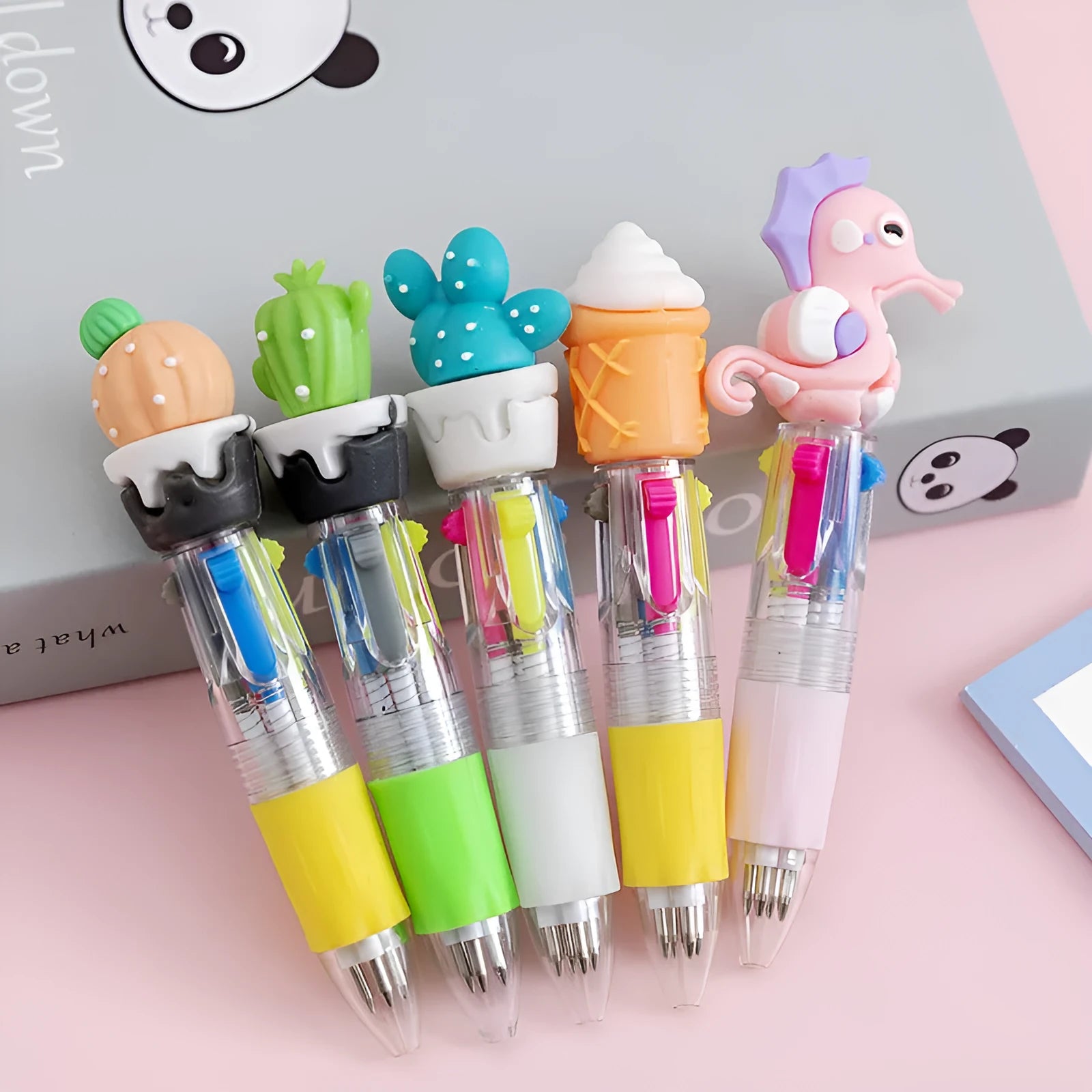 A press-action ballpoint pen with a four-colour cartridge, showing one of five random cartoon designs on the barrel.