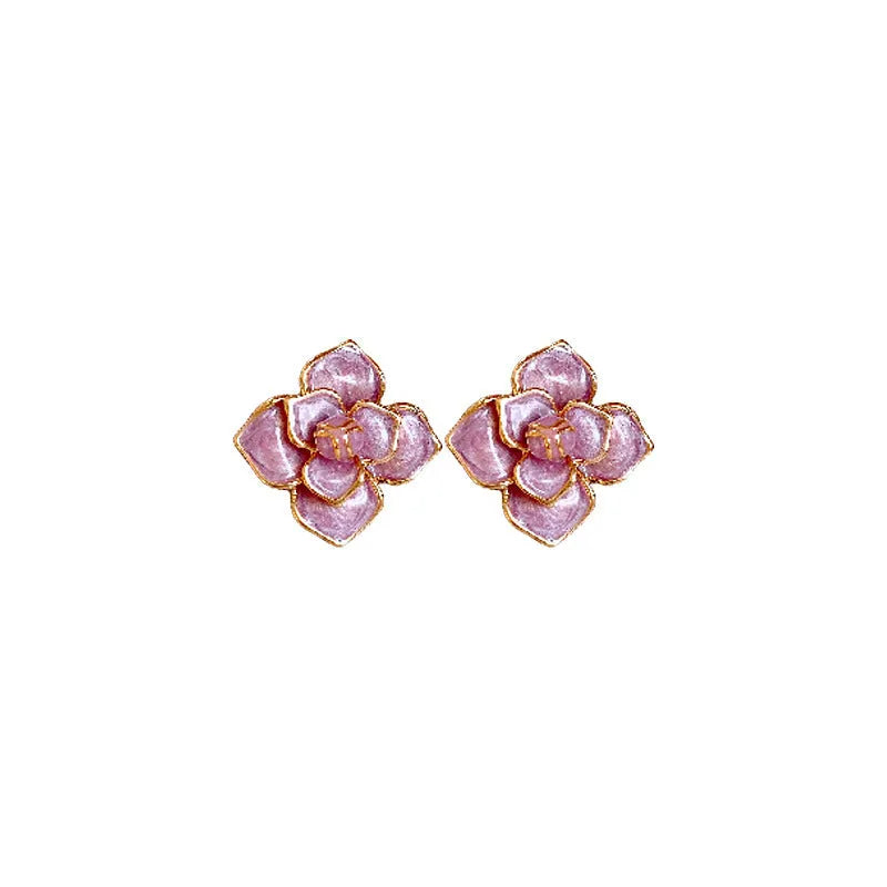 Close-up of gold plated purple flower stud earrings with iridescent oil-spot glaze on a copper base.