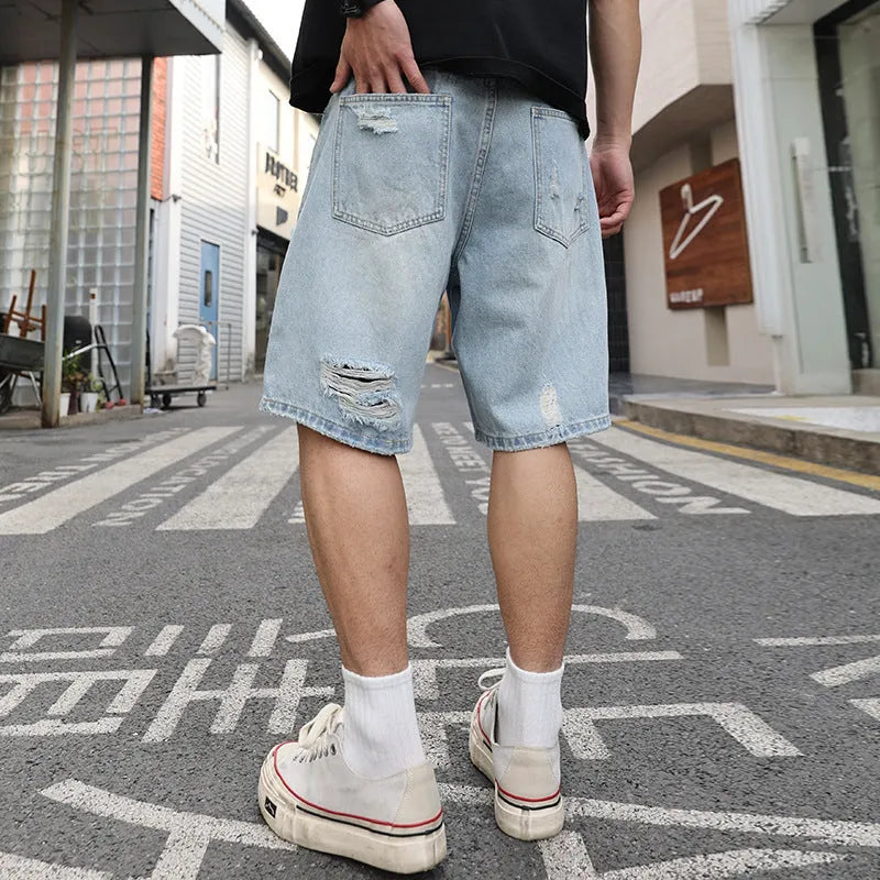 Men's light blue ripped denim shorts with distressed detailing and loose straight cut