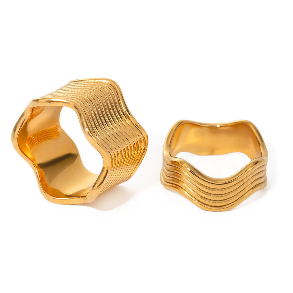 Geometric stainless steel ring with wide band and wave pattern design.