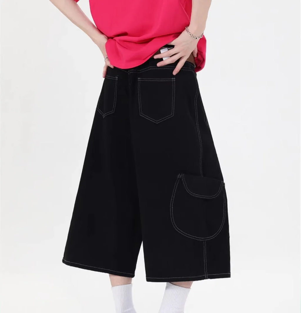 Red and black denim workwear shorts with multiple pockets, cropped length, and wide leg design