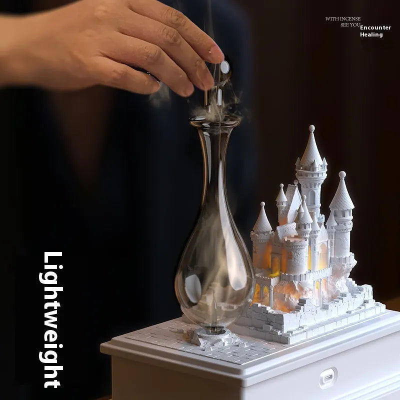 White medieval castle-shaped waterless cold fragrance diffuser with ambient lighting on a table.