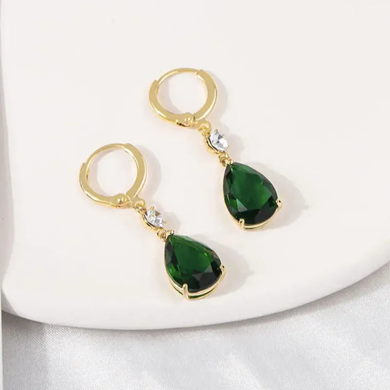 A pair of emerald green geometric teardrop alloy earrings on a plain background.