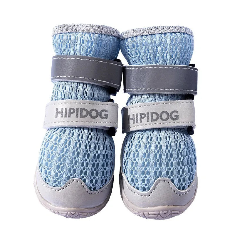 Pair of blue cartoon-style dog shoes with breathable PU uppers and anti-scald soles on a wooden surface.