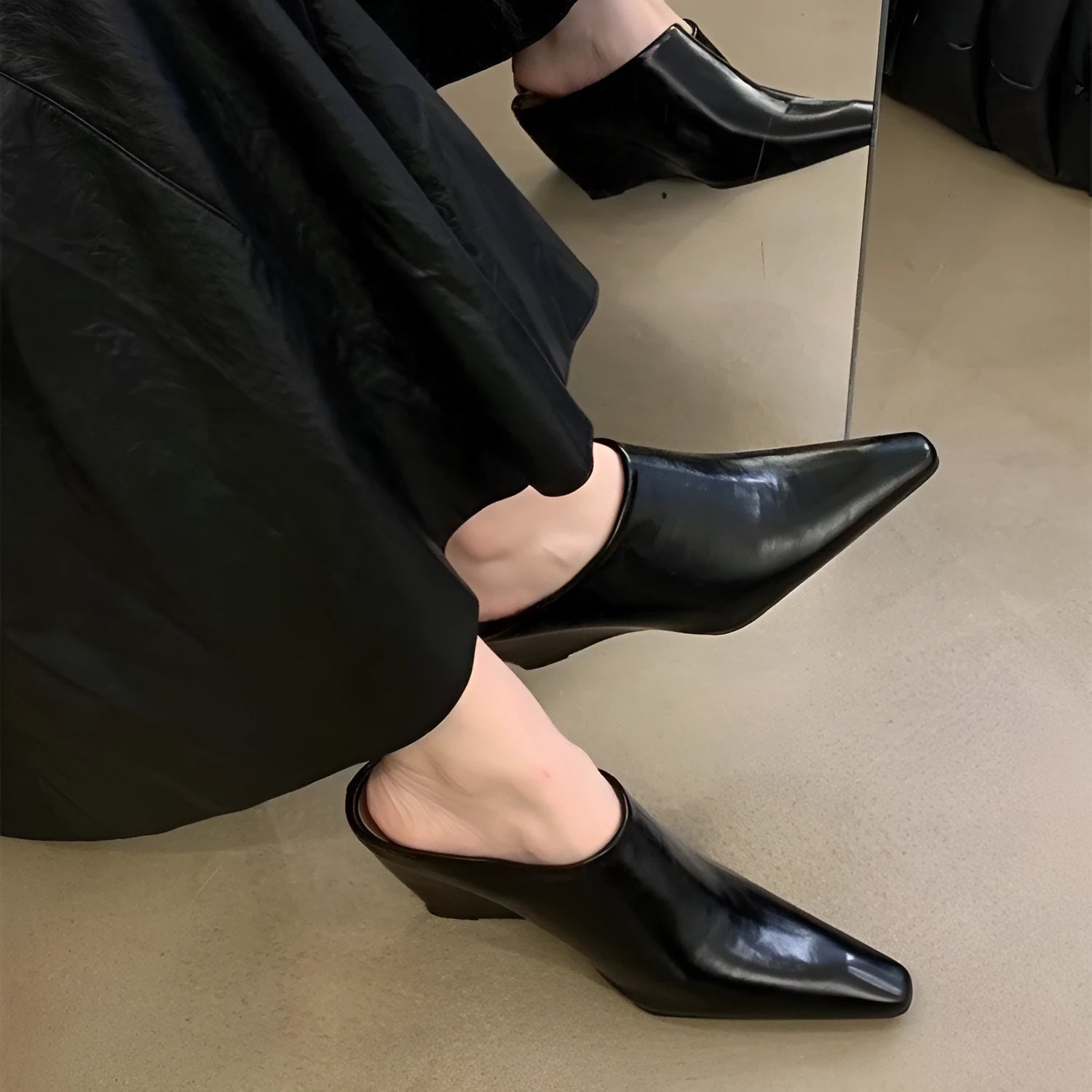 Women's black Wind Wedge closed toe half slippers with PU upper on a wooden floor.