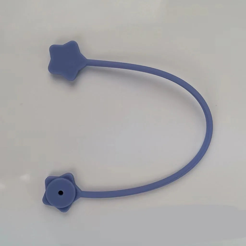 Purple silicone wire winder with magnet for organising headphone cables on a metal surface.